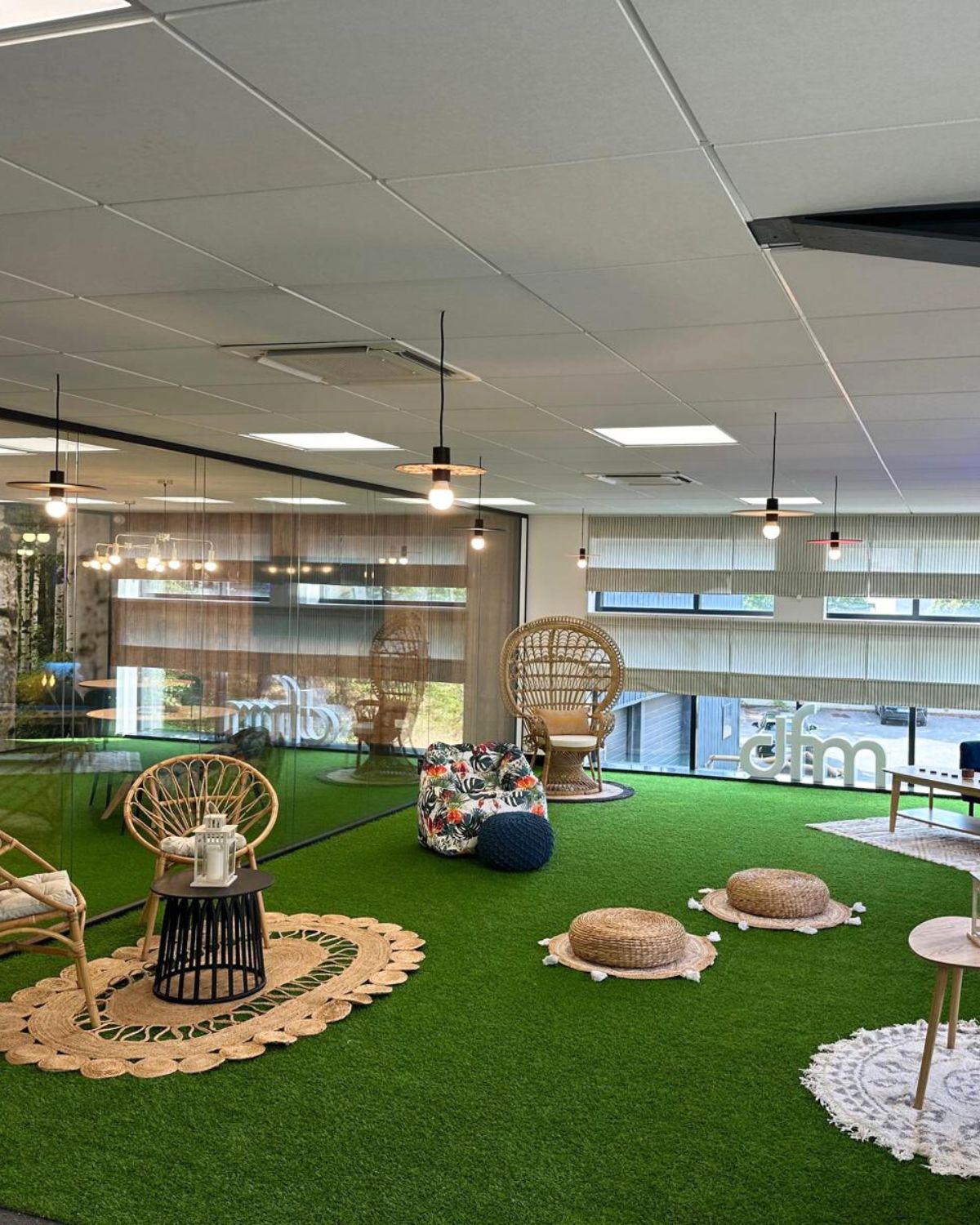 Aménagement d'un espace détente tertiaire avec gazon et mobilier rotin par BOULAY TERTIAIRE